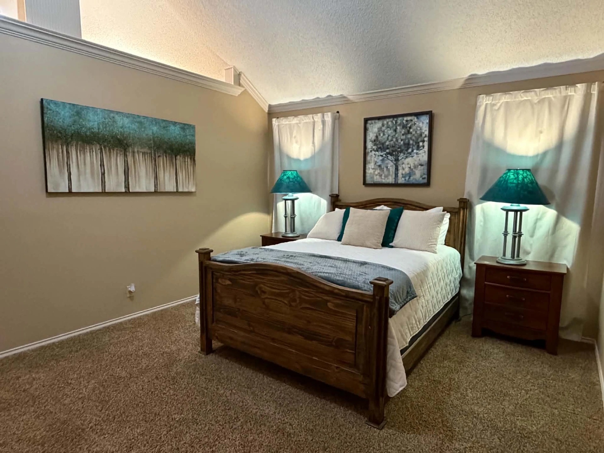 Primary bedroom at The Luxe Hideaway Too with queen bed and warm lighting